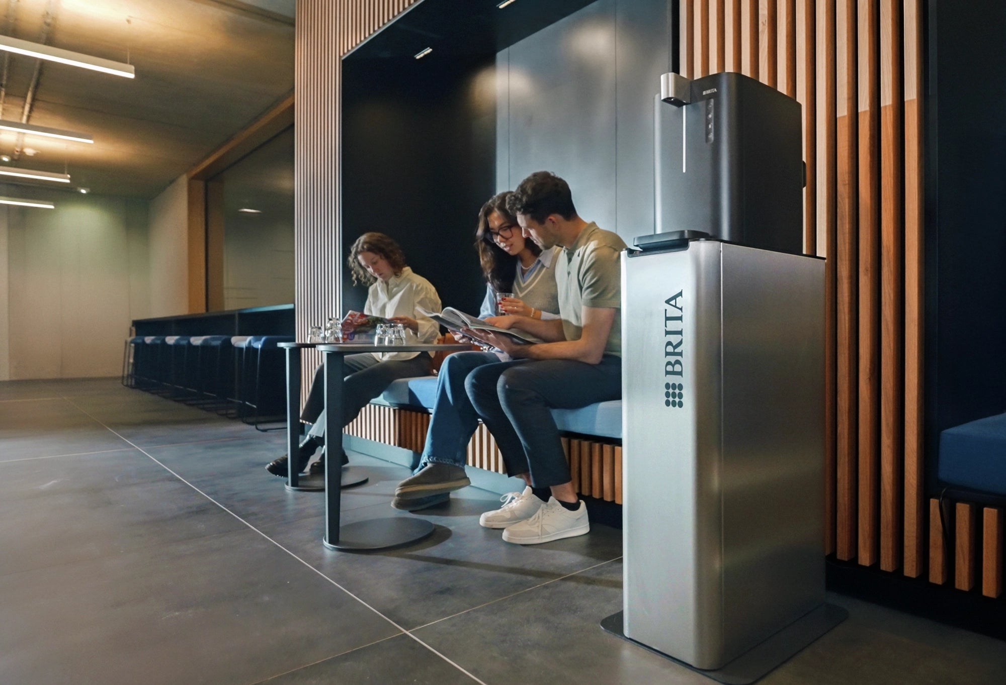 People sitting in a modern waiting room with a BRITA water dispenser