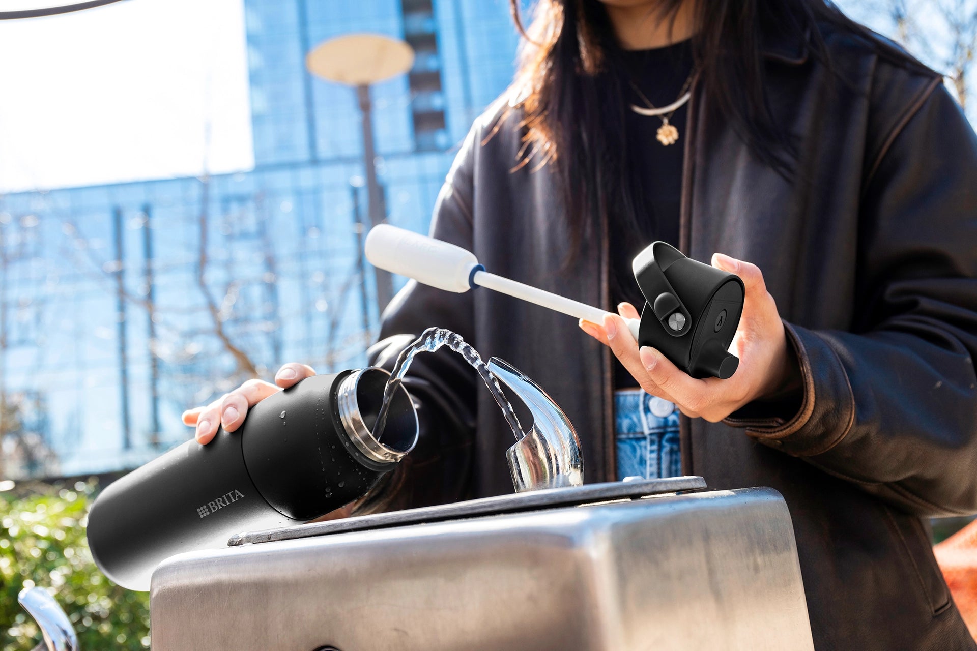 BRITA LARQ iQ Filter Bottle being filled with water at a public drinking fountain.