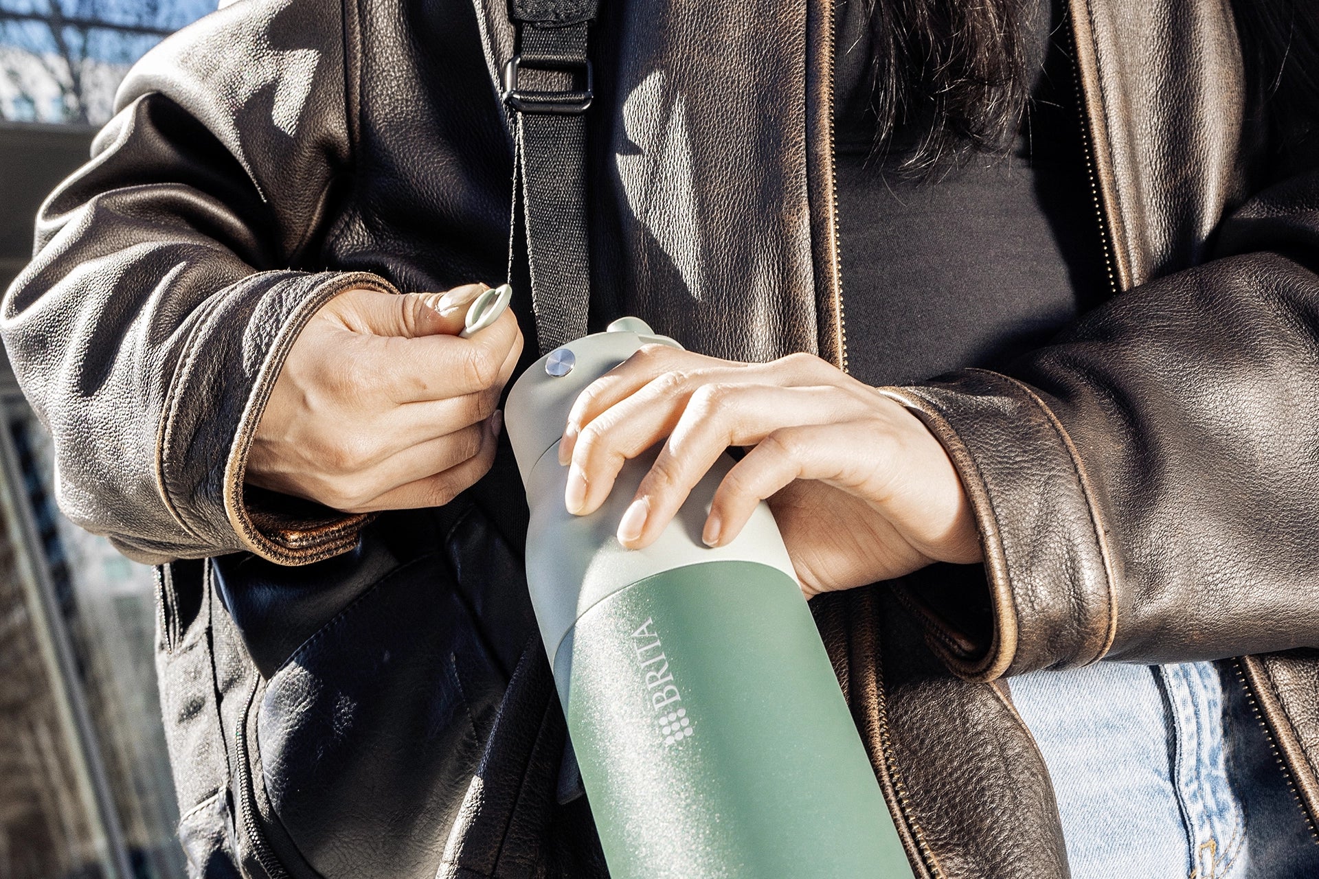 Close-up of a BRITA LARQ Bottle with green handle accessory attached to the lid