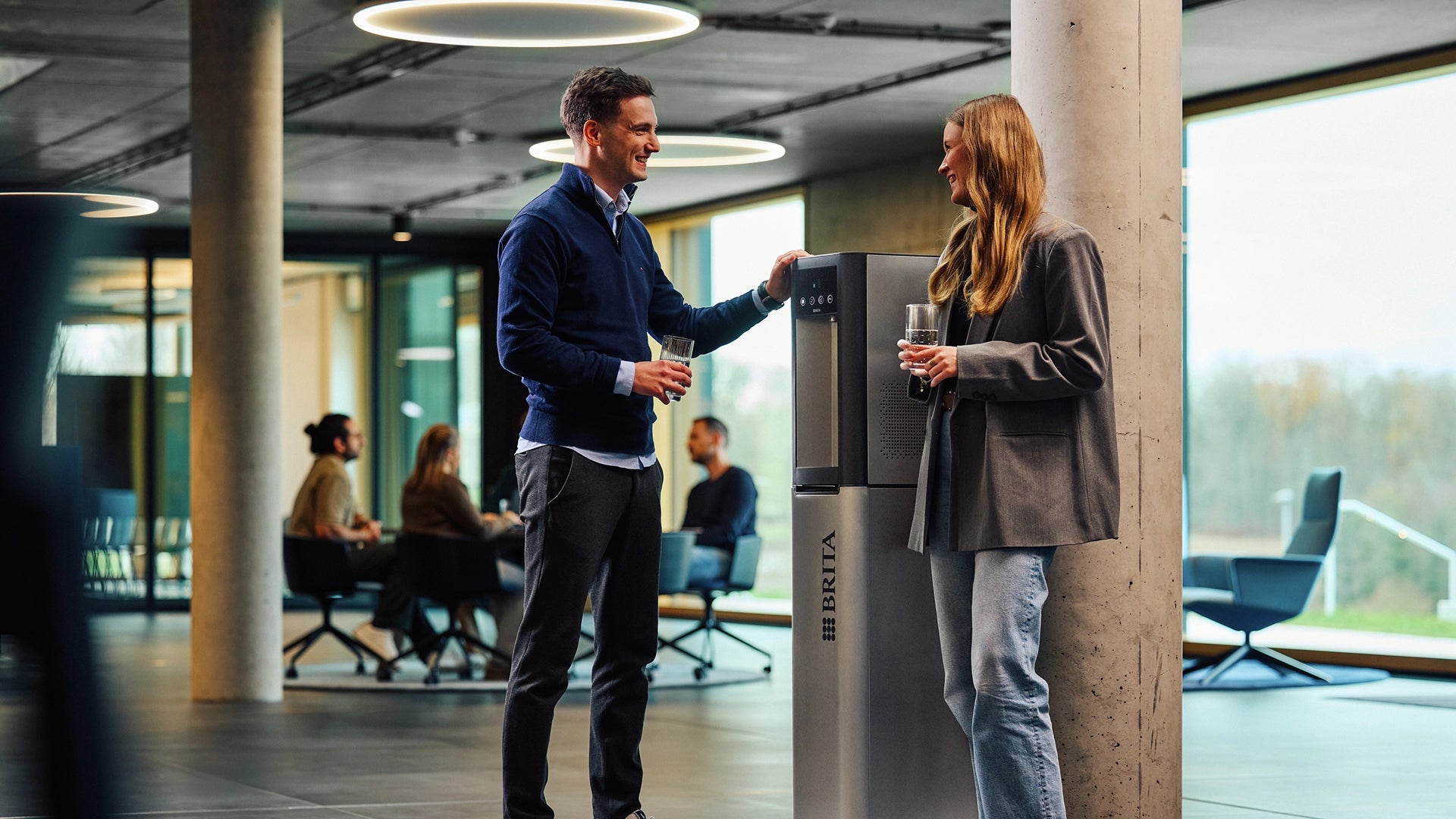 Two people at a BRITA water dispenser in an office setting