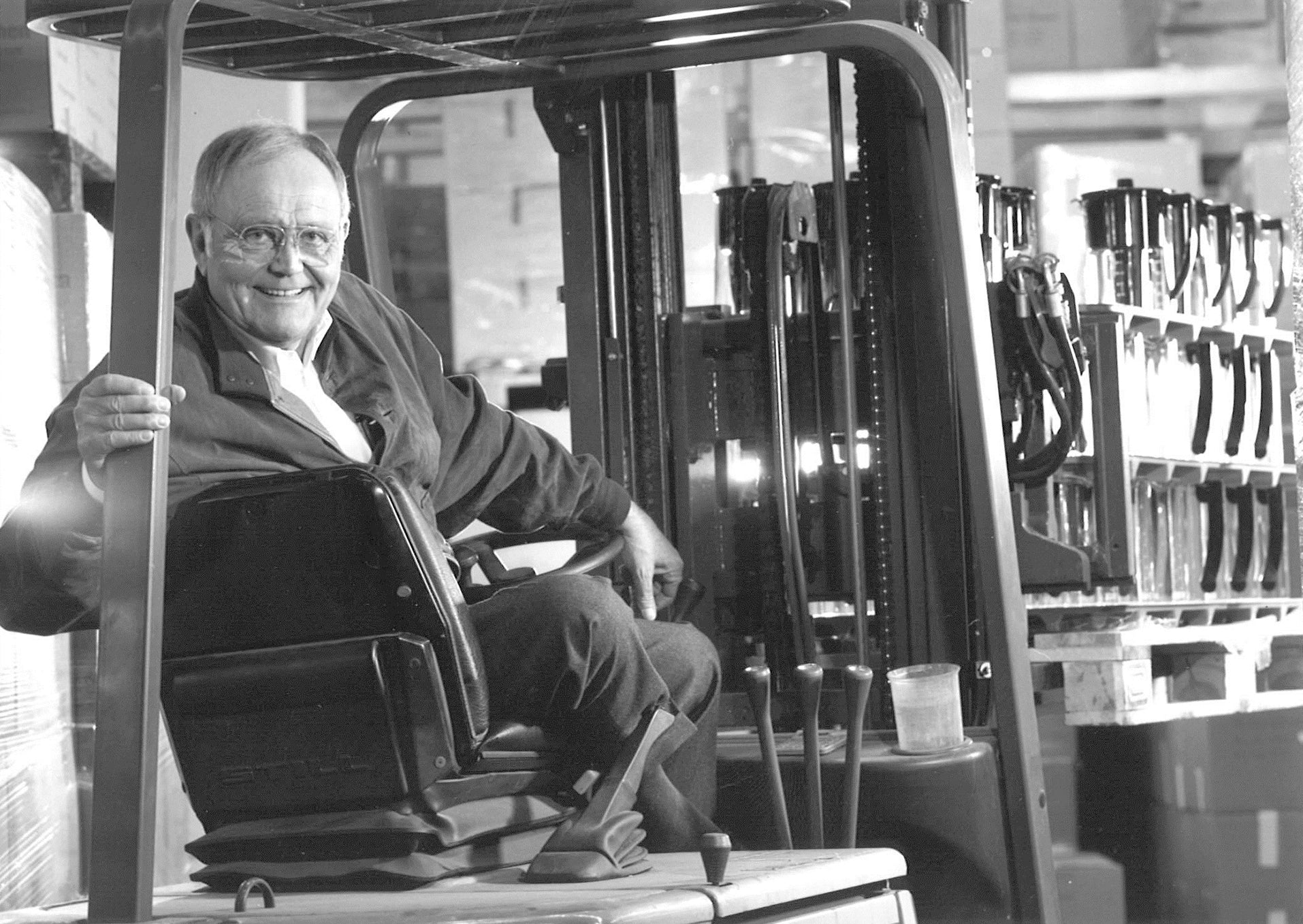Heinz Hankammer, founder of BRITA, sitting inside a forklift in a factory.