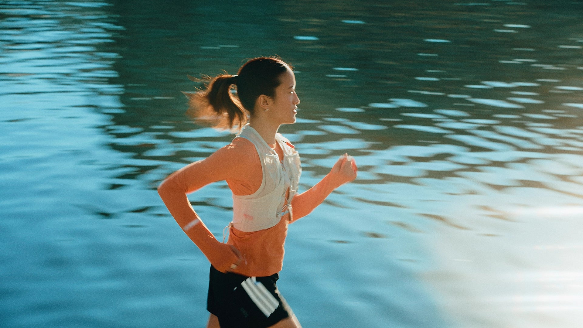 Woman running by a riverside.