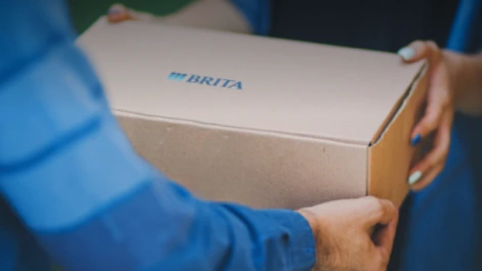 Person holding a cardboard box with BRITA logo.