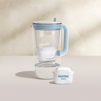 Un'acqua filtro Caraffa in vetro in blu su sfondo beige