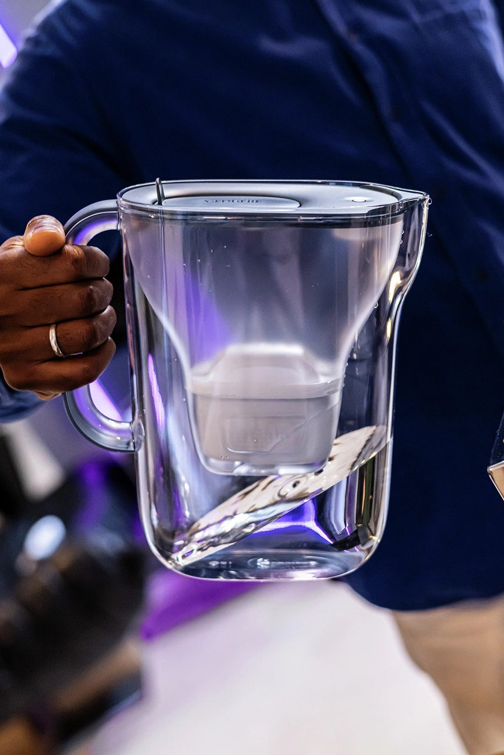 BRITA Style Essential blue water filter jug being carried by a person.