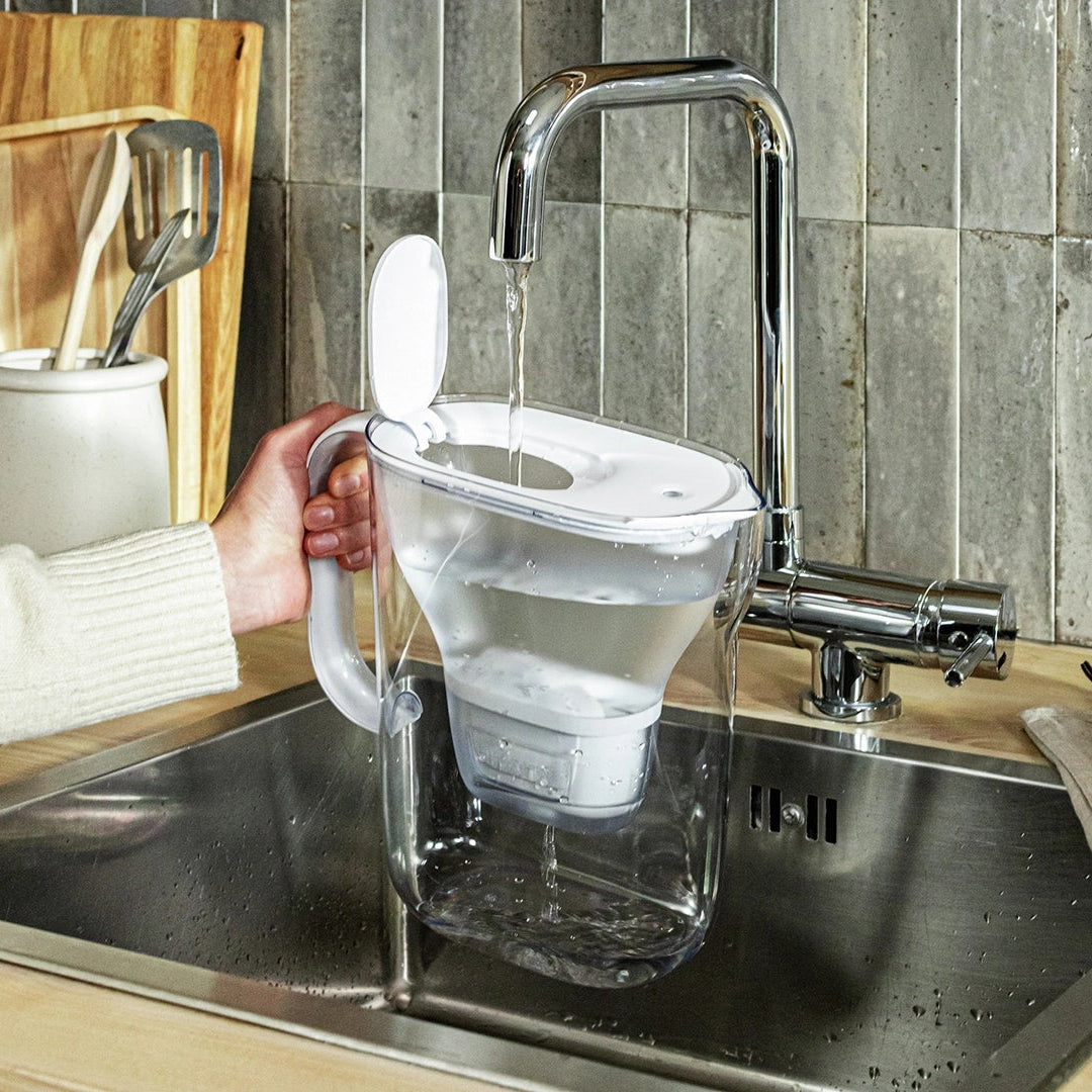 White BRITA Style Essential being filled with tap water under a kitchen faucet.