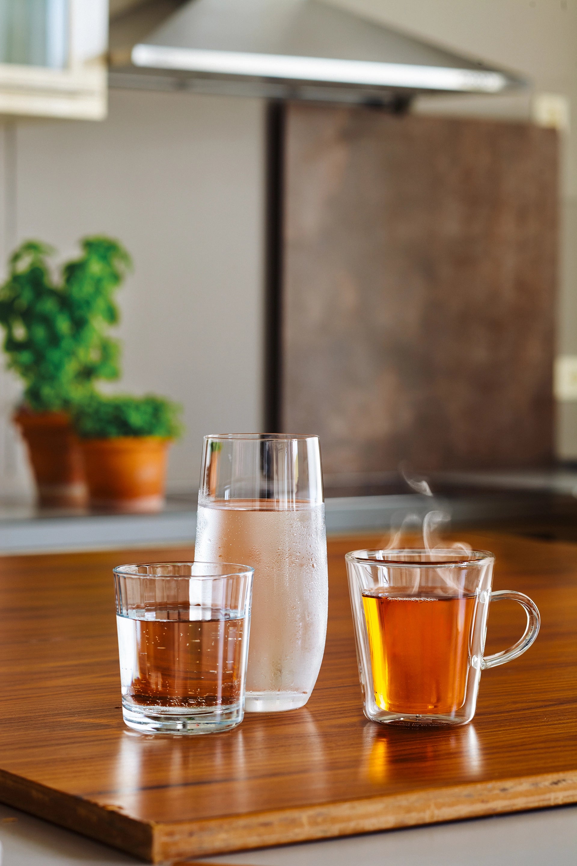 Glass of water, chilled water in a tall glass and a glass cup of tea displayed beside BRITA YOURCE cool.