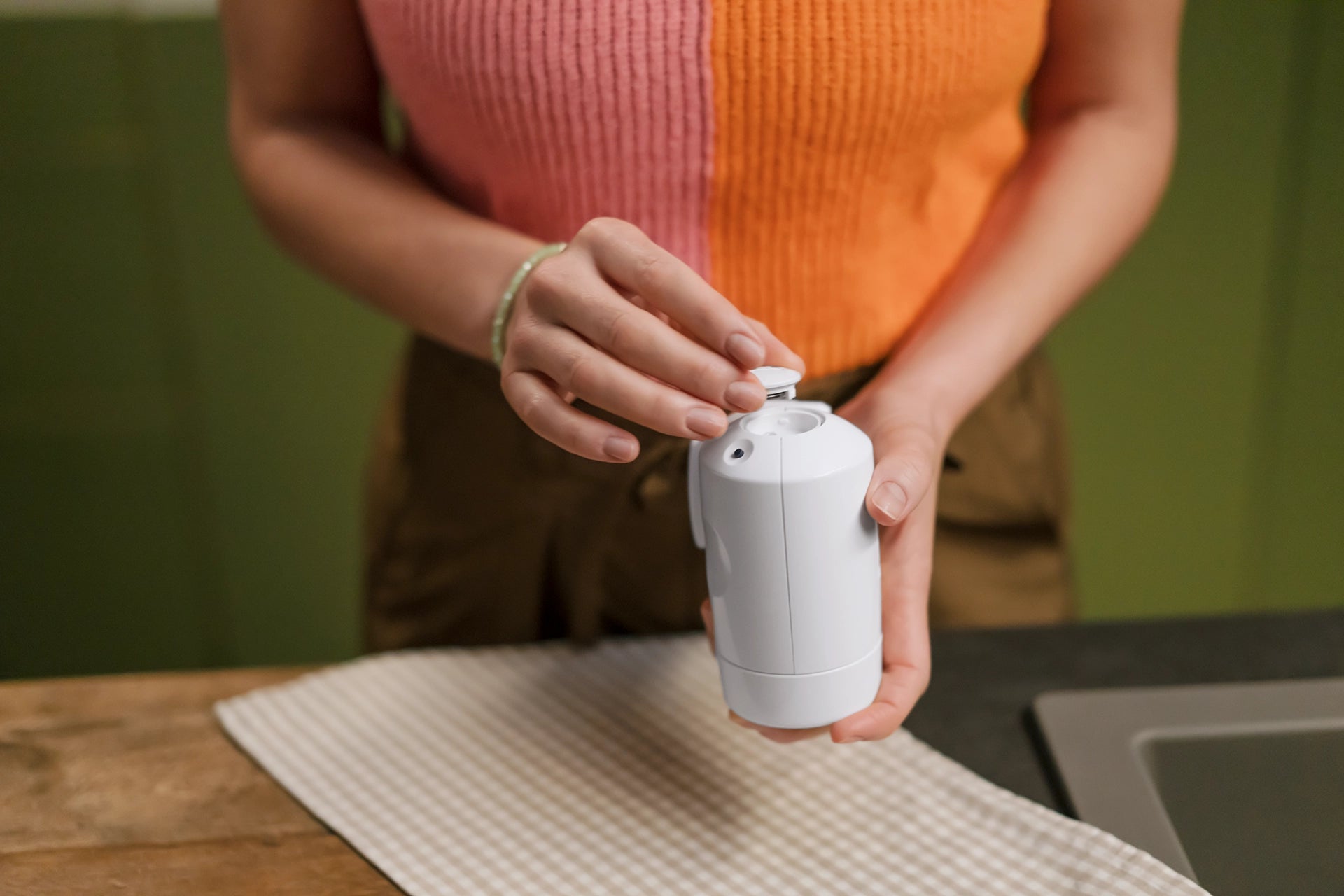 Person opening the battery compartment of a BRITA ON TAP filter
