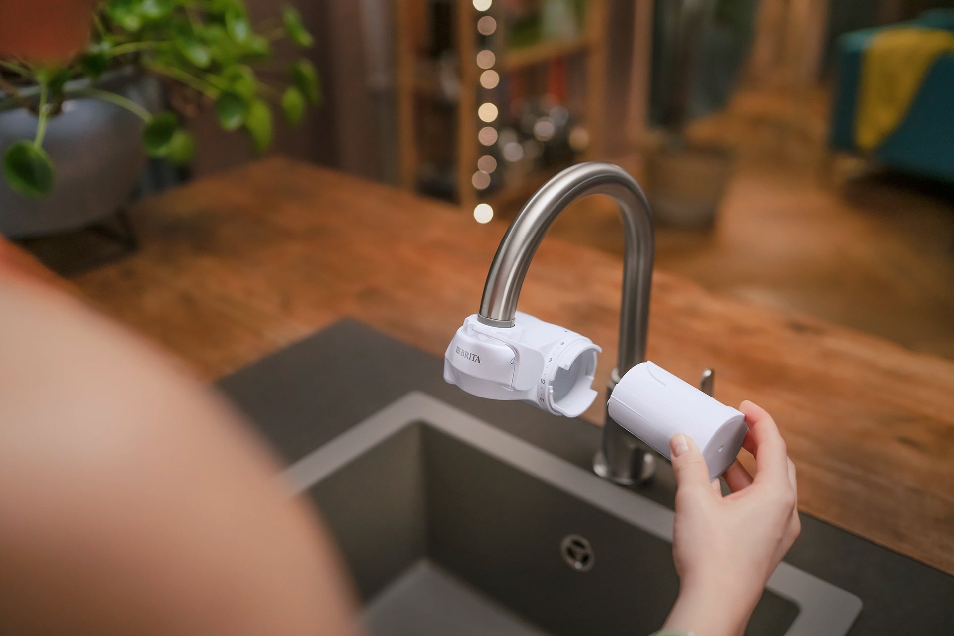 BRITA ON TAP filter cartridge being replaced on a kitchen tap.